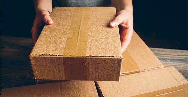 Person holding a brown shipping box