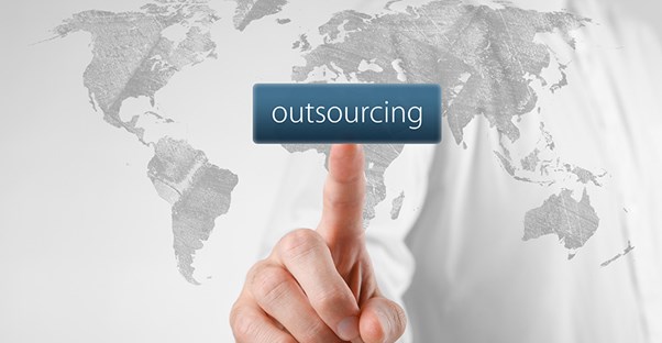 hand pointing at word outsourcing with map of world in the background