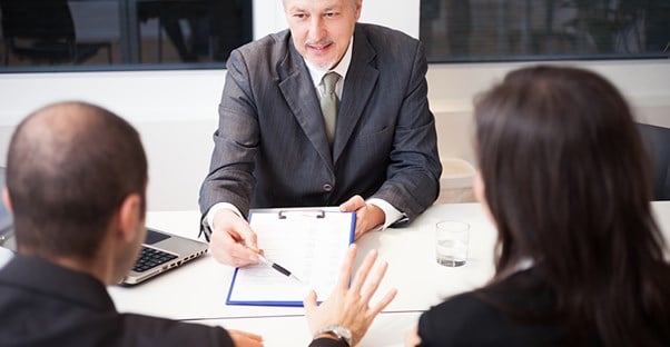 two people discussing a business loan with a banker