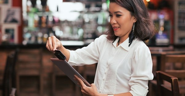 Restaurant owner scanning a credit card with a mobile credit card processing service