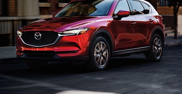 a red 2018 mazda cx-5 driving down the road