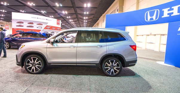 a side view profile of the 2019 honda pilot at an auto show