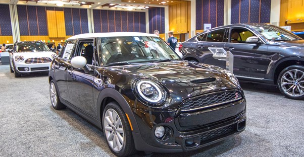 a purple mini cooper with white top at an auto show