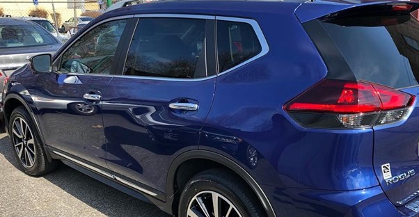 a 2019 blue nissan rogue in a parking lot