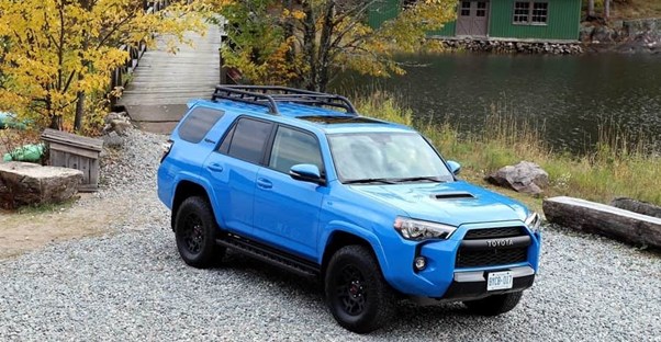 a blue 2020 toyota 4runner parked outside of a cabin