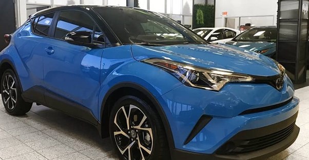 a blue 2019 toyota chr in an auto showroom