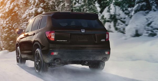 a blacked out 2019 honda passport driving in the snow