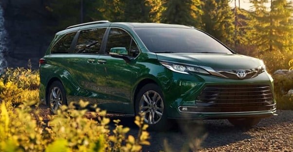 a green toyota sienna photographed in a forest setting