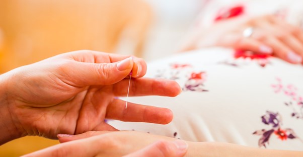 Midwife pokes pregnant woman with a teeny tiny needle