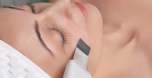 A woman with long eyelashes relaxes and enjoys a massage