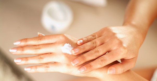 A customer spreads lotion onto their hands