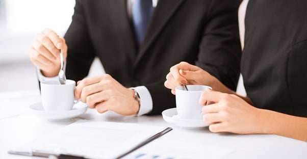 Tax attorneys drink tea while they look over paperwork