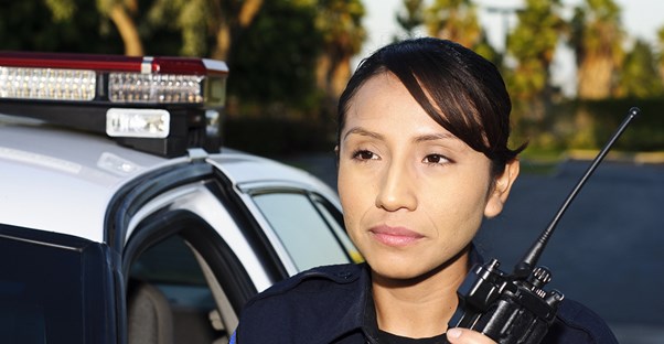 A police officer uses her walkie talkie