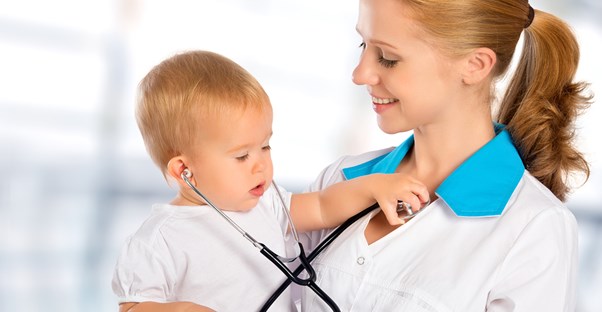 A physician assistant plays with a baby