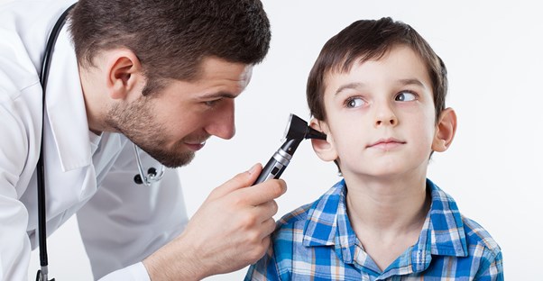 A pediatrician checks the temperature of a little boy