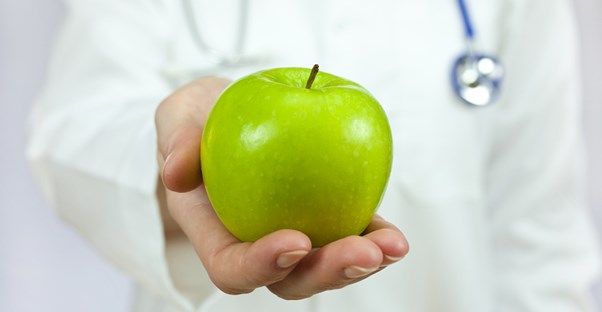 A dietitian holds an apple