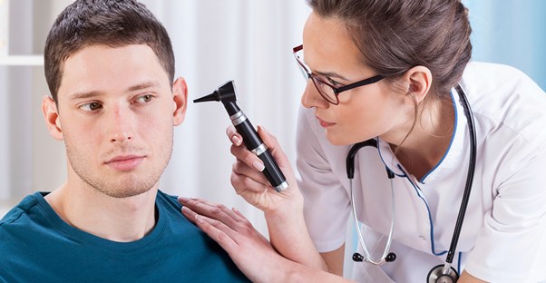 A doctor inspects a patients ear