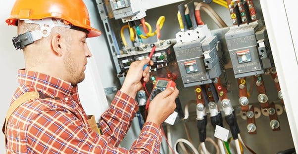 An electrician studies wires