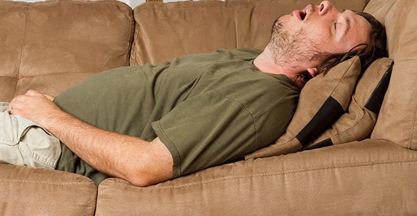 man snoring on couch