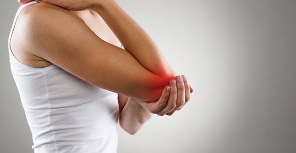 woman holding elbow because she is experiencing chronic pain