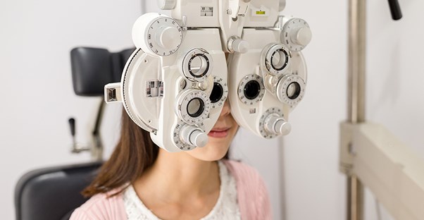 girl at eye doctor taking vision test because she has strabismus