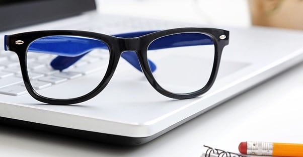 glasses sitting on top of a computer to represent living with strabismus