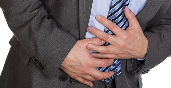 guy holding stomach because he is experiencing the symptoms of salmonellosis