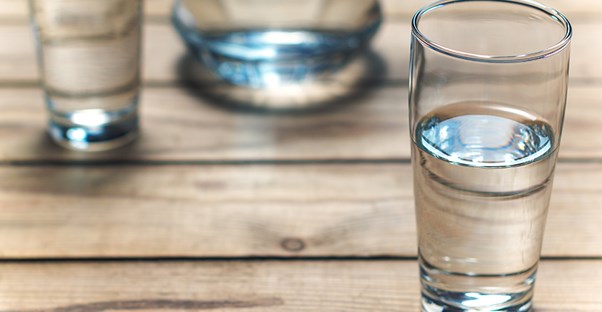 glass of water on table to represent dry mouth
