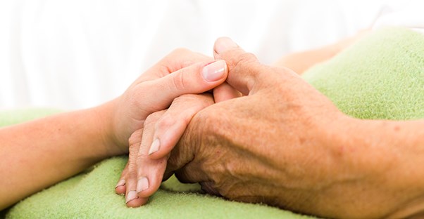 person holding hands with their elderly loved one who has lewy body dementia