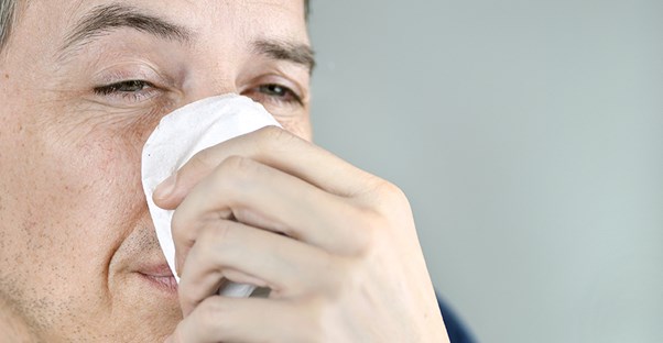 Man sneezing. Sinus infection causes. 