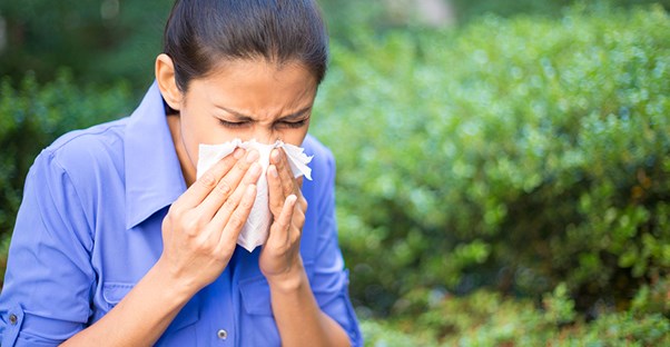 Woman sneezing. Sinus infection relief.