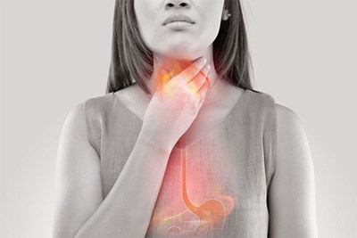 A woman in gray-scale with a red and orange overlay of her esophagus and stomach