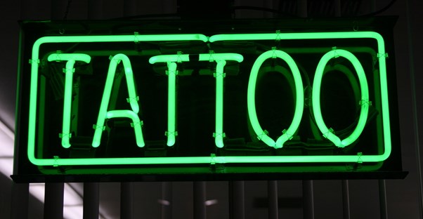 the fluorescent sign of a tattoo parlor