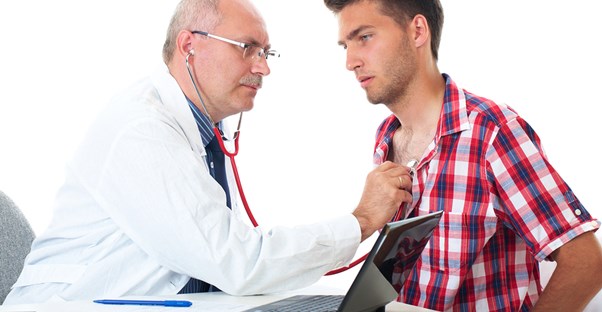 a doctor inspecting a patient for gynecomastia symptoms