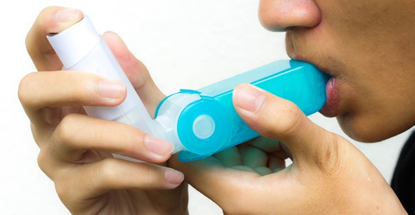 a woman using an inhaler for asthma