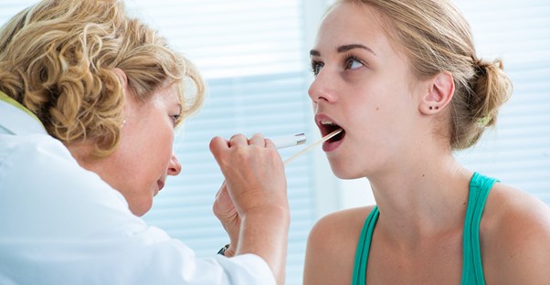 a doctor inspecting a patient for strep throat