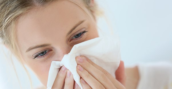 A woman deals with a runny nose