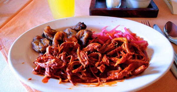 Spiced pulled pork and other delicacies are plated attractively in a Roma neighborhood restaurant.