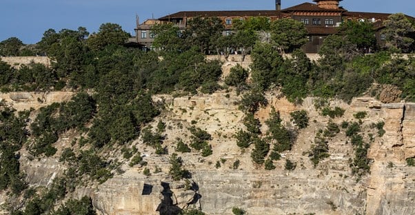 a large wooden hotel sits on the edge of the North Rim of the Grand Canyon