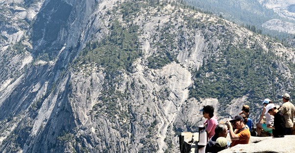 visitors stand at a Yosemite overlook point