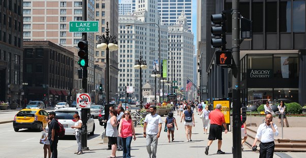people bustle down Chicago's Magnificent Mile on Michigan Avenue