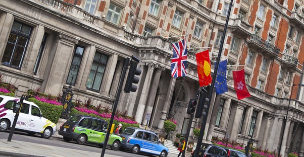 a luxury international hotel has various national flags flying outside its entrance