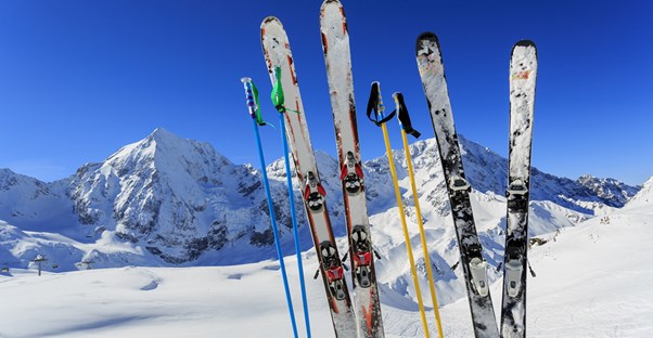 skis and poles are stuck into the ground on the side of a mountain ski run