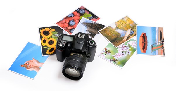 a camera sits on top of multiple printed travel pictures