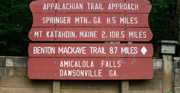 an appalachian trail marker displays distances to nearby cities