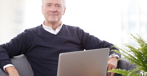 a senior citizen looking for a job on his laptop