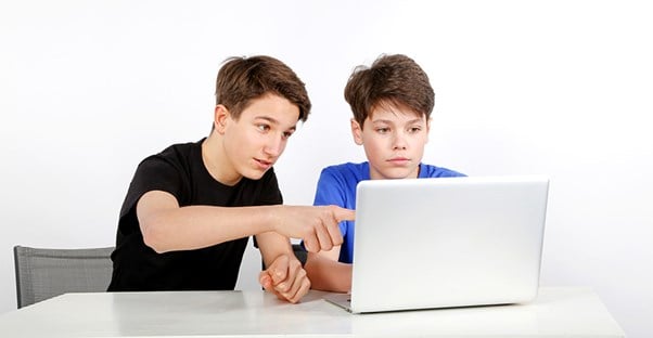 Two boys looking at a laptop computer