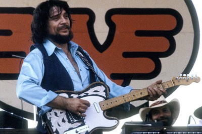 waylon jennings at a concert playing his guitar