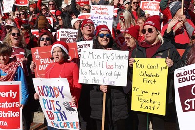teachers protesting wearing red and holding signs
