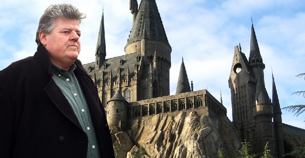 Robbie Coltrane standing in front of Hogwarts